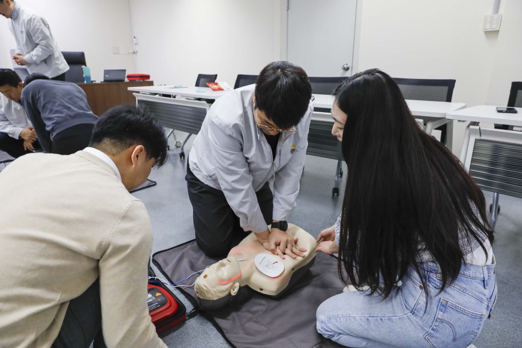 직접 심폐소생술 실습을 해보는 KCC글라스 구성원들.