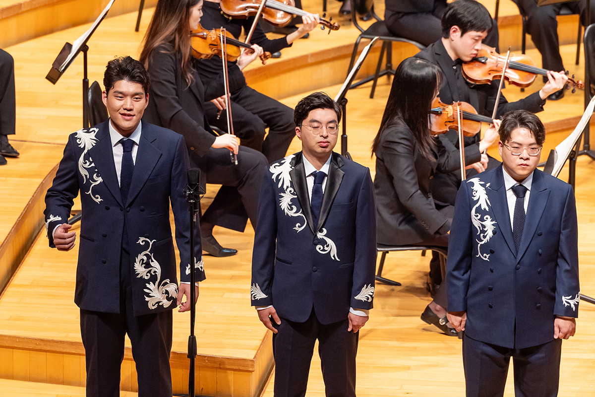 미라클보이스앙상블 단원들이 오케스트라 연주단과 눈을 맞추며 서로를 응원하고 있다, 단원들이 목소리에 희망을 담아 노래하고 있다.